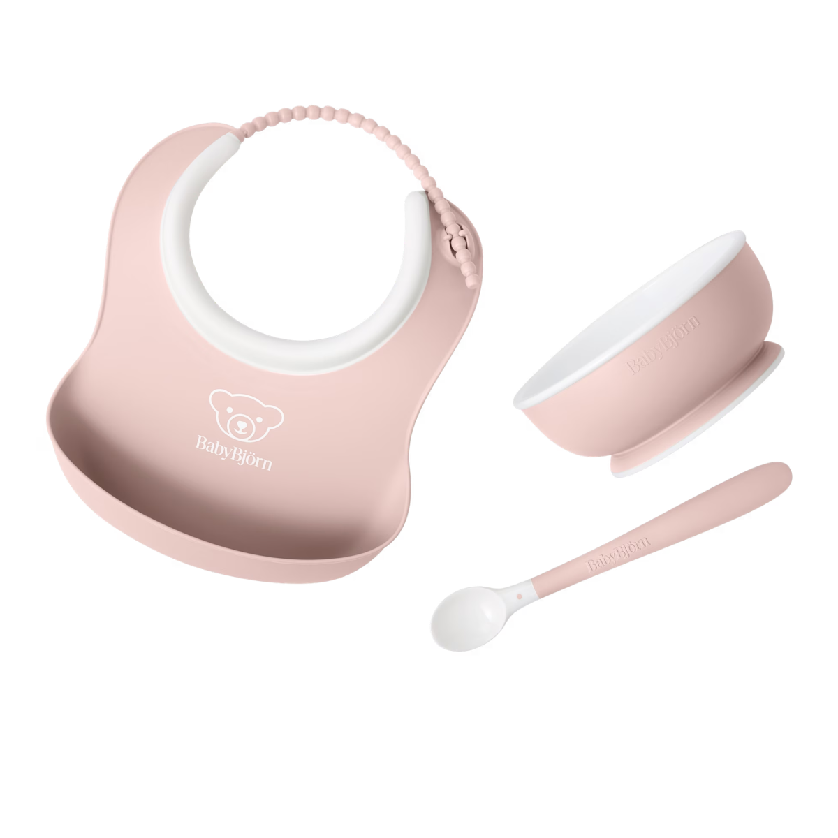 Pink BabyBjörn baby bib with food-catching pocket, plus matching pink bowl and spoon.